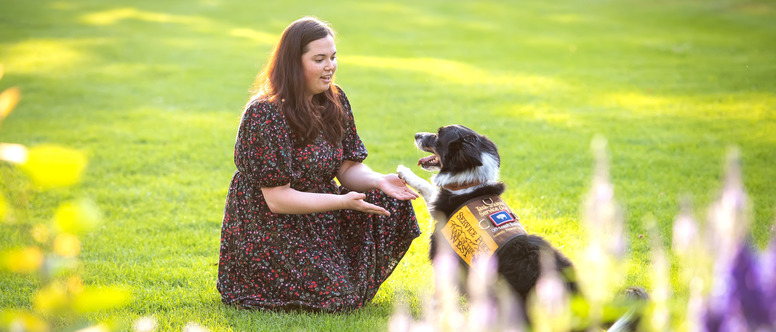 Student working with her service dog in Prexy's Pasture.