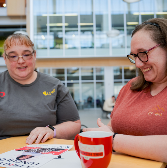 Image of TRIO advisor and SSS student reviewing an event poster.