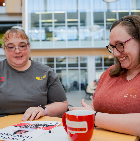 Image of TRIO advisor and SSS student reviewing an event poster. 