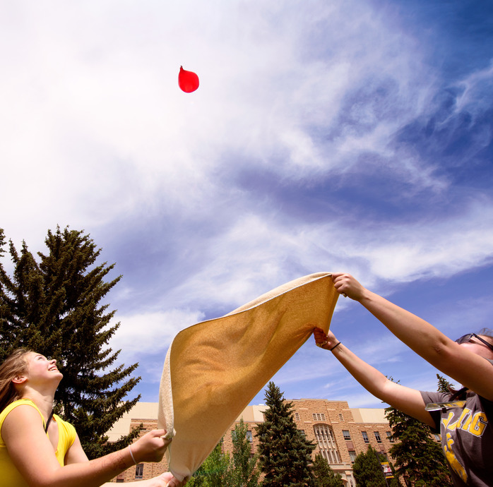 Two students playing a yard game on campus.