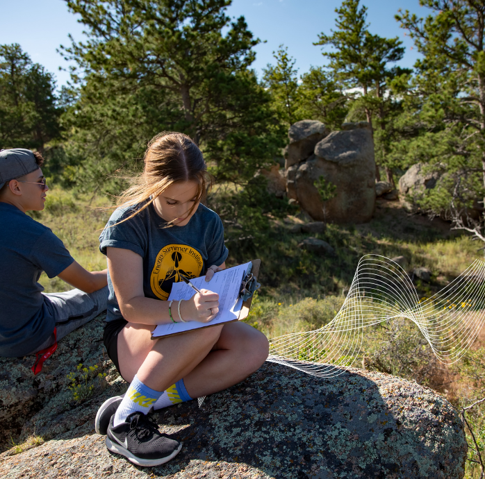 Student taking notes outside