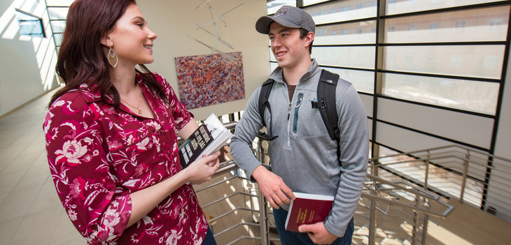 Two students chat in the stairwell of the EIC building