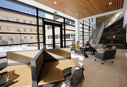 atrium with sunlight streaming in and study tables by staircase