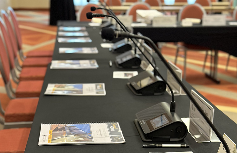 a boardroom table set with ERC folios and microphones