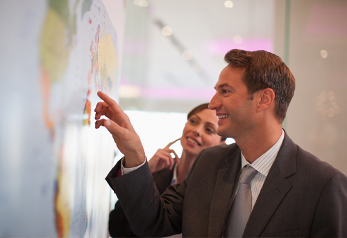 Students looking and poniting at a wall mounted map