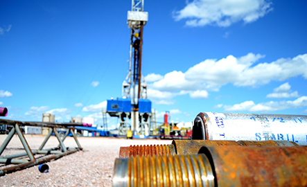 drilling rig in background with some casing tubes in the foreground