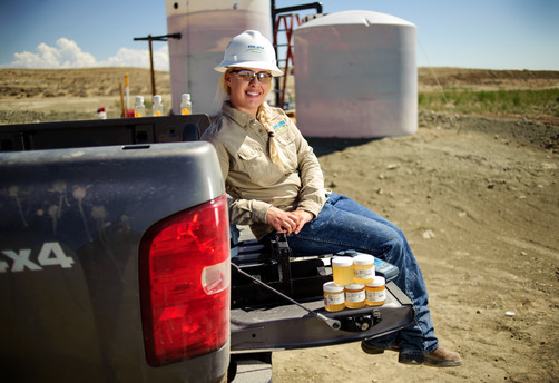 alumni sitting in bed of truck with wearing a hardhat