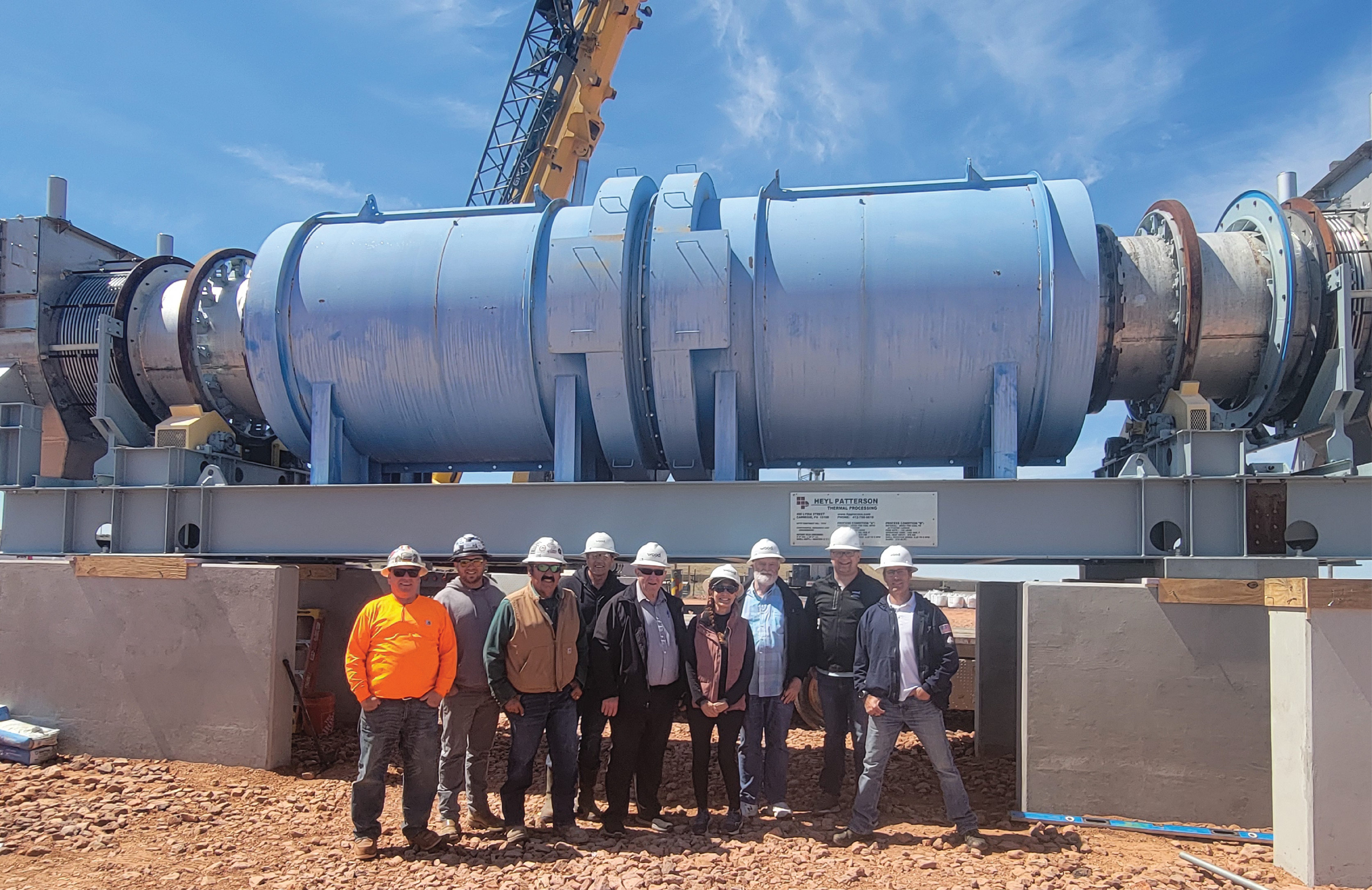 Calciner machine with a group of workers posing in front