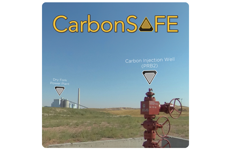The carbonsafe well head in a field with Dry Fork Station in the background.