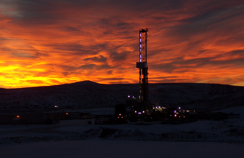 ccus drill rig silhouette against a deep orange sunset