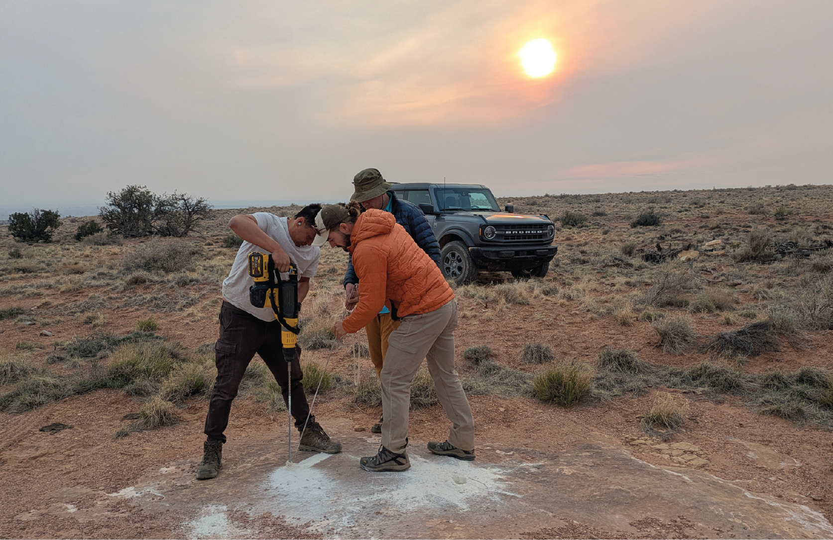 team drilling a hole in a rock