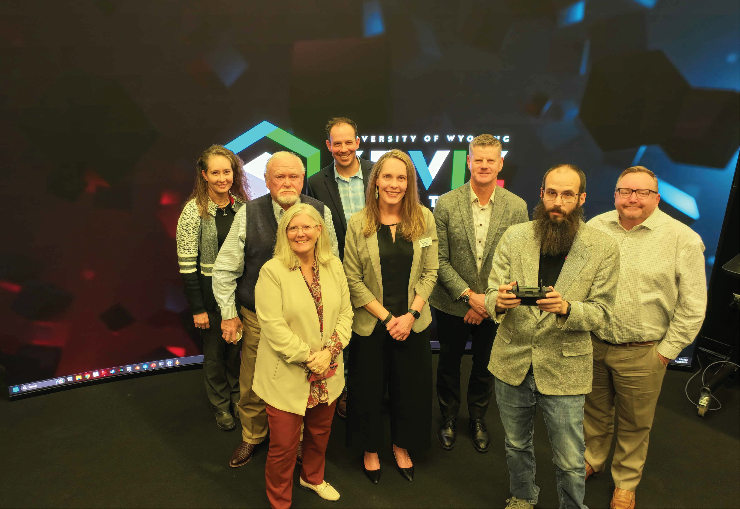 A group of SER team members and legislators in front of the new large display screen