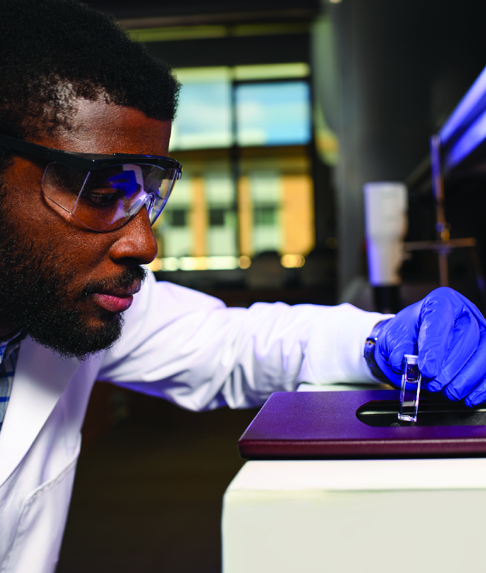 Scientist looking at vial
