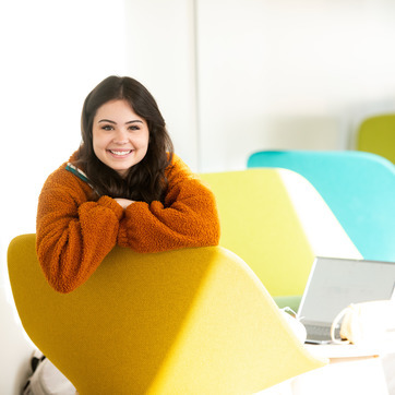 Student sitting in study chairs in the Education Initiative Building