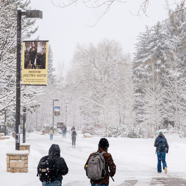 Students walking around Prexy's Pasture in the snow.