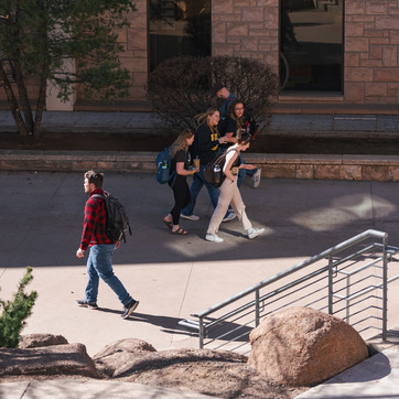 Students are walking to class between the Wyoming Union and Coe Library.