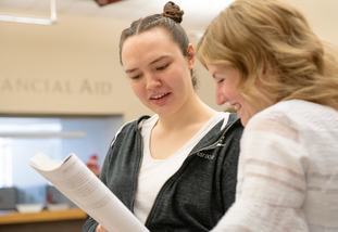 A UW staff member helps a student outside the financial aid office.