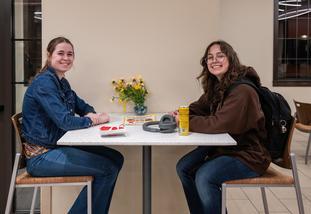 Students sit at a table in the south hall