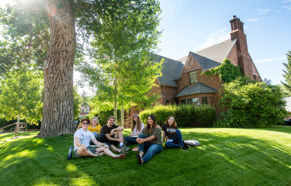 Students relax on the lawn in front of the Honors House.