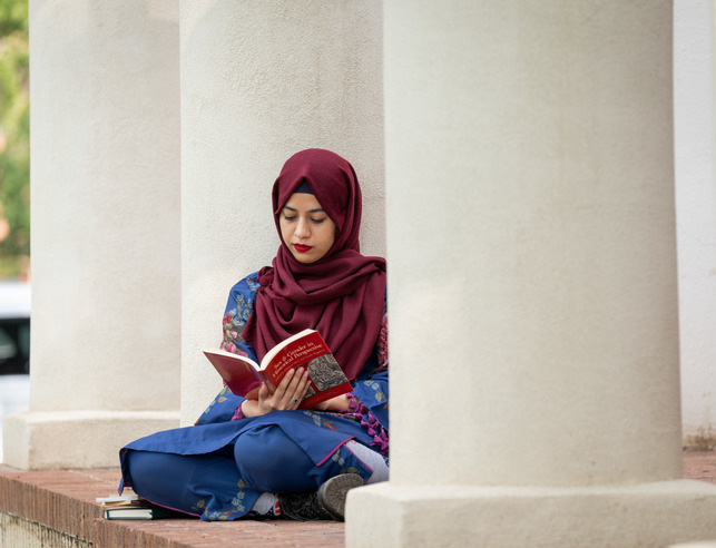An international student from Pakistan sits outside the Cooper House.