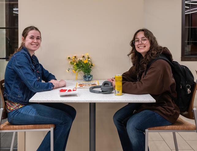 Two students sitting at a table in south hall.