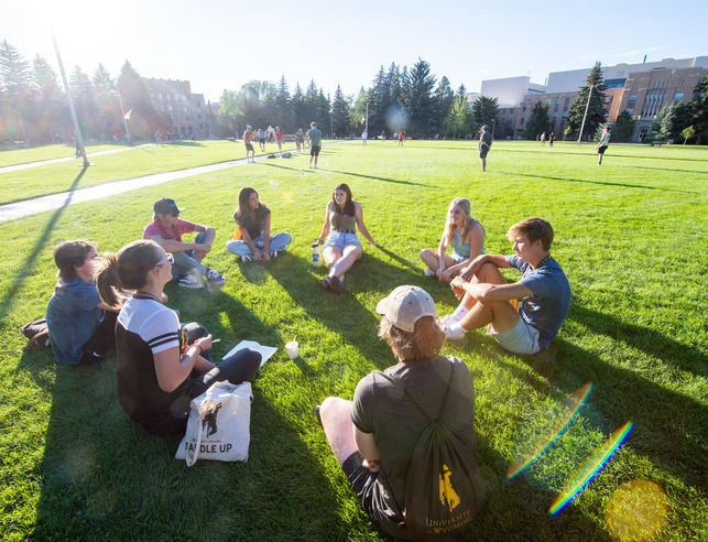 Students sitting on the grass in Prexys Pasture.