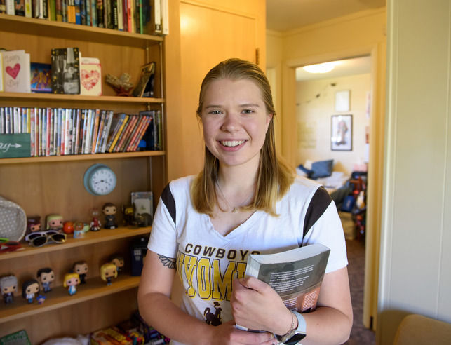 A student standing in their room at Landmark Apartments.