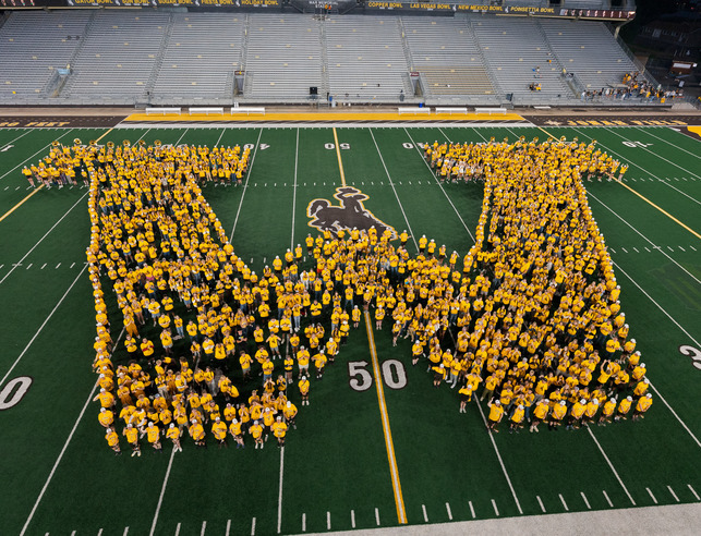 Students in the Class of 2028 forming a W on the football field.
