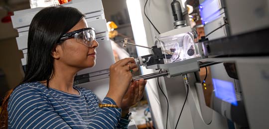 A student works on a machine inside a lab.