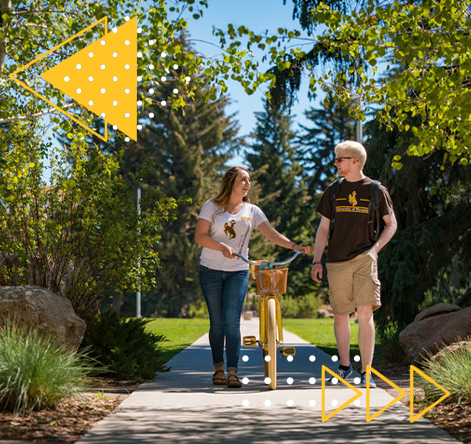 Two students walking on campus with a bike