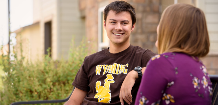 two students chatting on a bench outside