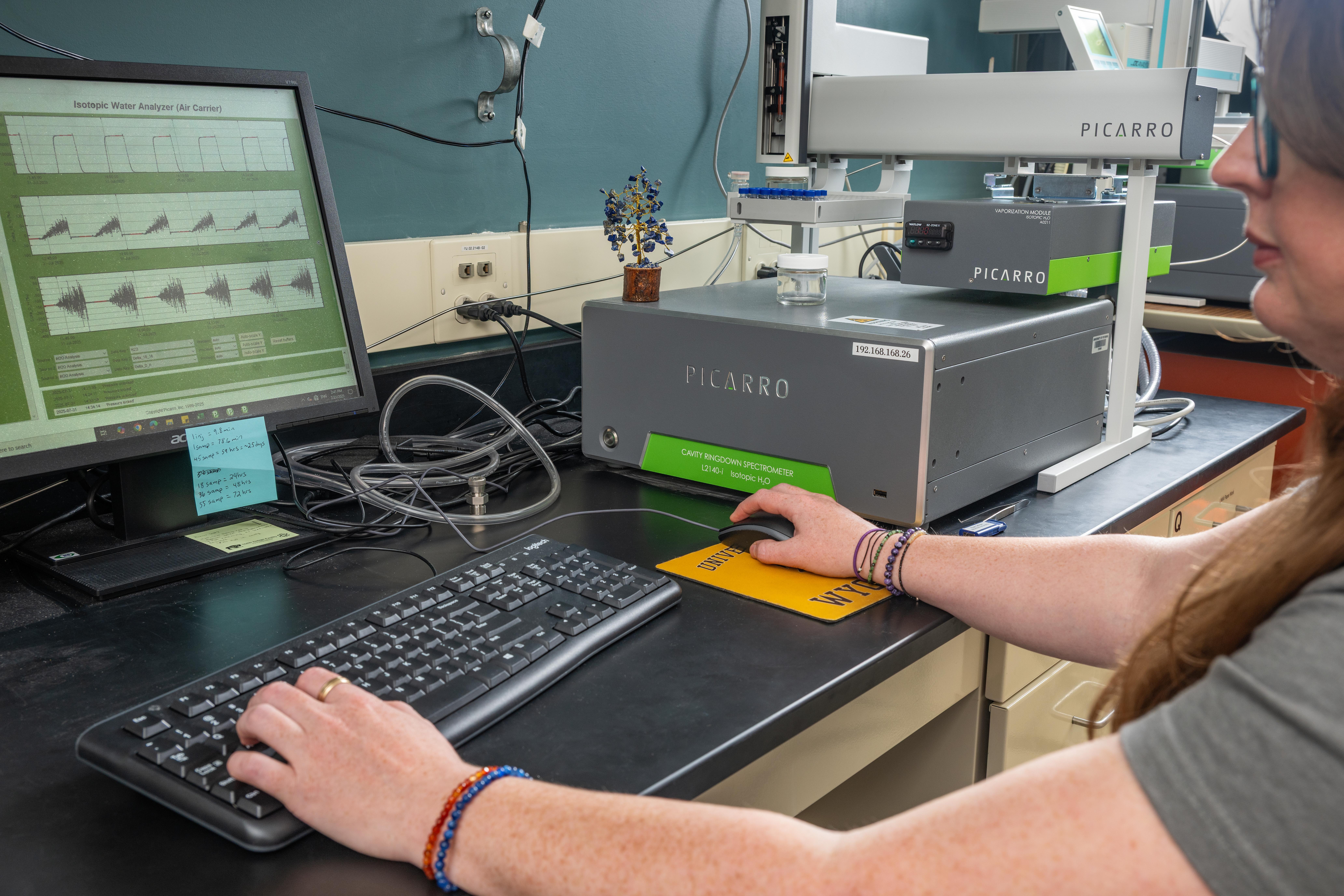 Technician sitting at a picarro isotope analyzer