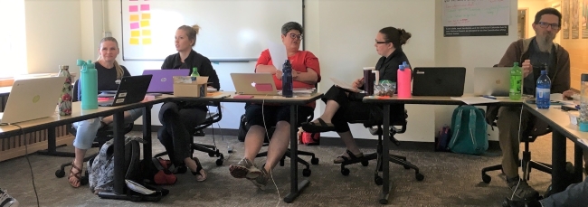 Group of 5 MSC students collaborating around a table in Wyoming Hall