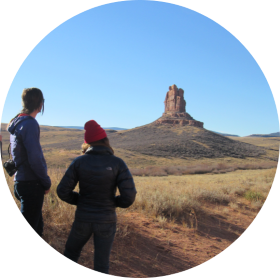 Photo of two graduate students looking at distant "3 Sisters" rock formation