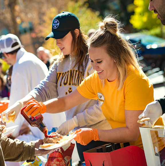 student serving food at a UW event