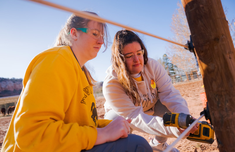 Two students mending a fence in Kanab, Utah for an alternative spring break