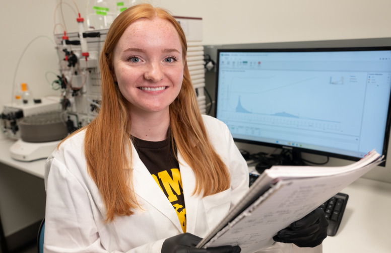 Scholar poses in a lab