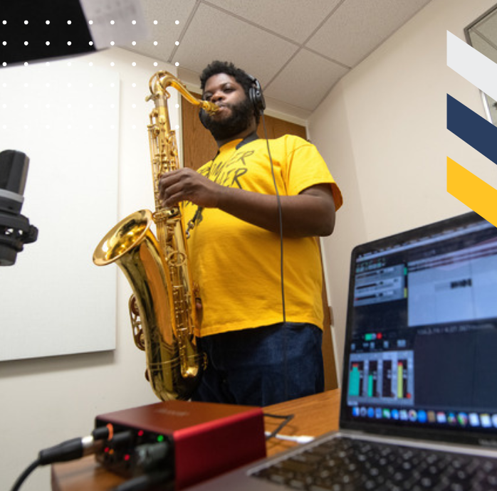 A student playing a saxophone in a recording room