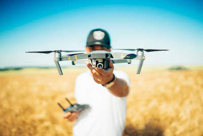 Person holding a drone in a field.