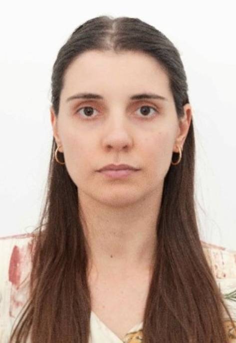 Cristina Palma has long brown hair and gold hoop earings