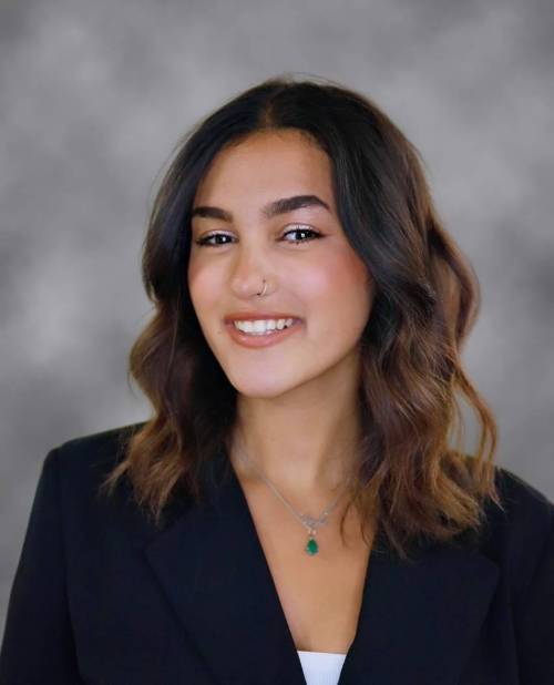 Smiling woman wearing black blazer.