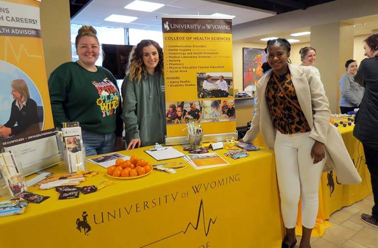 College students standing at a information table.