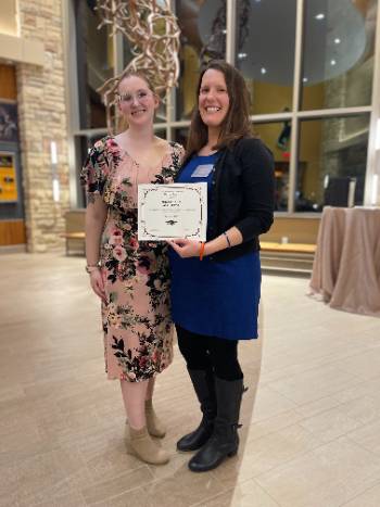 A faculty member recieving an award from a student.