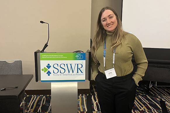 A woman standing next to a speaker podium.