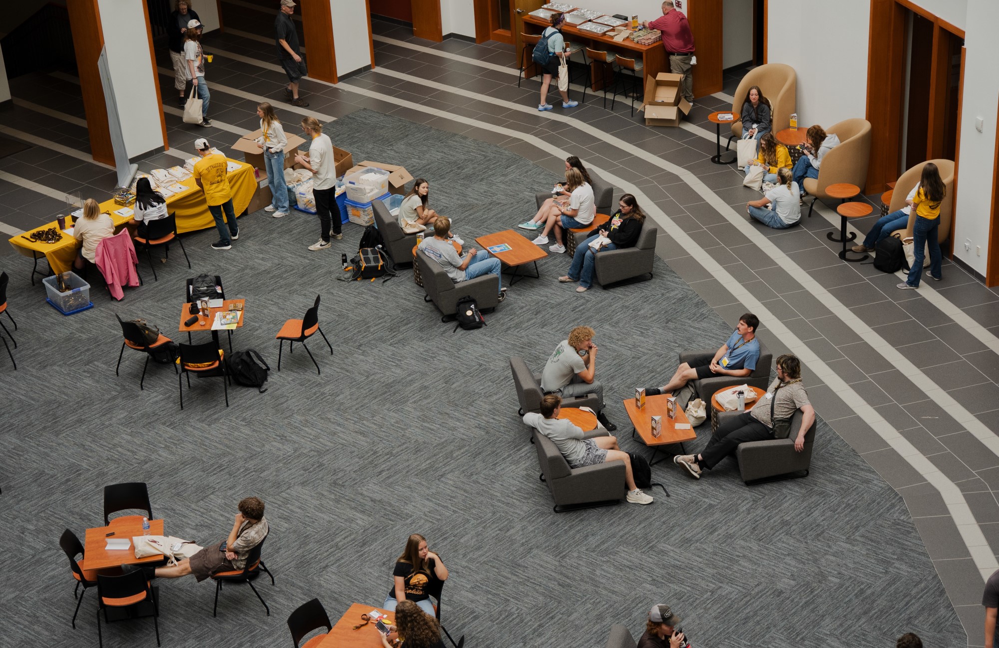 Taken from above, students sitting in chairs in an atrium.