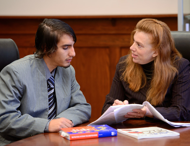 Dr. Stephanie Anderson sitting with professionally student looking over documents