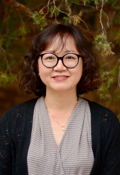Dr. Su Young Choi standing in front of a tree
