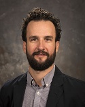 photograph of Dr. Nicholas Crane in front of a bookshelf