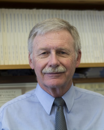 Jim King in front of a bookshelf