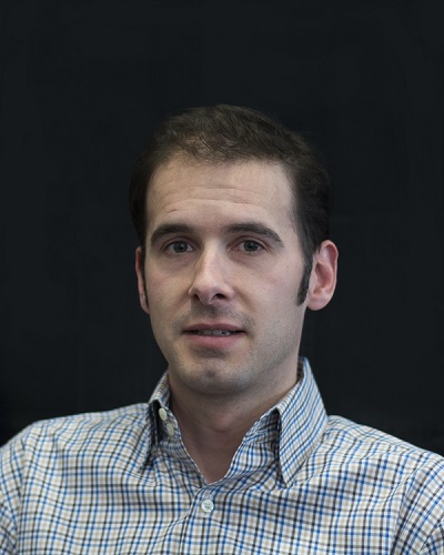 Justin Piccorelli in front of a black background